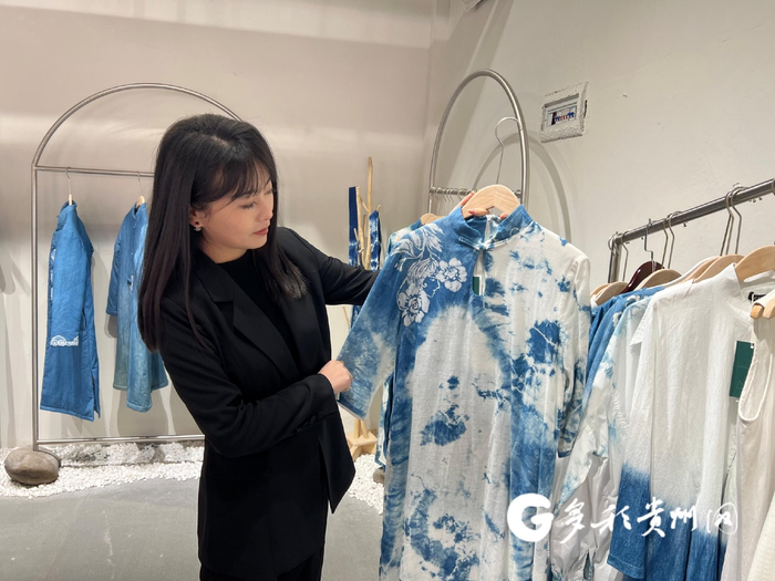 王以向记者介绍店内服装