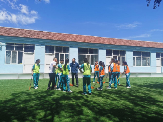 ▲学校旱地冰球比赛上，马海军教给队员们如何进行攻防。