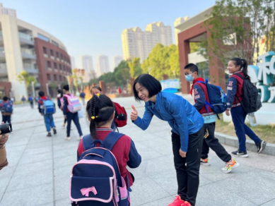 ▲备战省大课间比赛，罗英正在和学生聊训练，为她们加油鼓劲。 