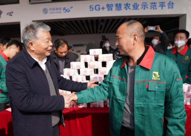 1月10日，凌继河（左）为种粮能手发放奖金。新华社记者 周密 摄