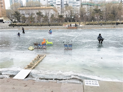 1月11日上午，亮马河，冰面上有家长带着孩子玩耍，有商贩在此做出租冰车冰鞋的生意。新京报记者 张静姝 摄