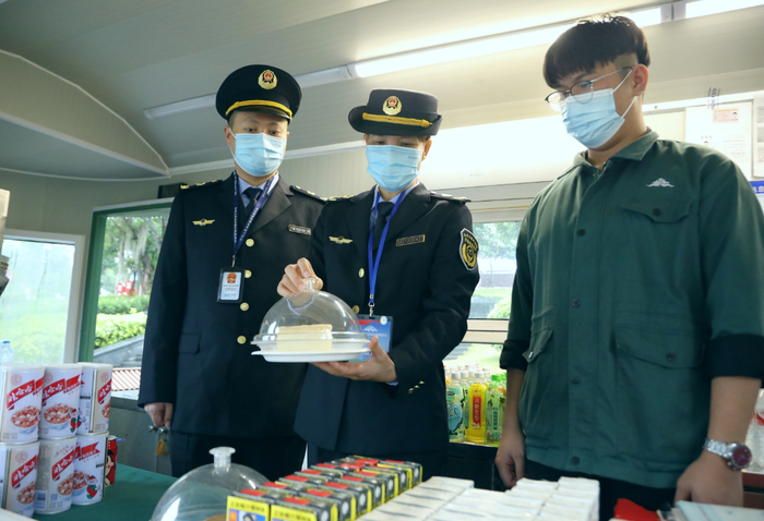 执法人员对景区一家职工食堂直营点进行检查。（何正君 摄）