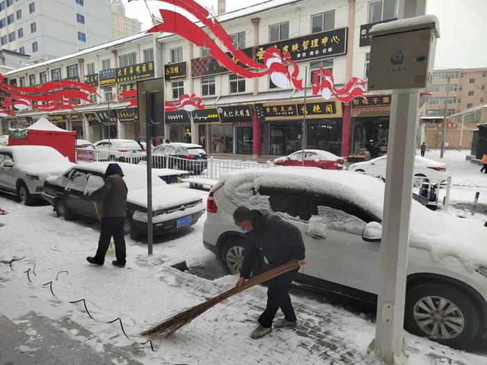 13日凌晨，康乐出现降雪天气，市民清扫道路积雪。（图：李娟）