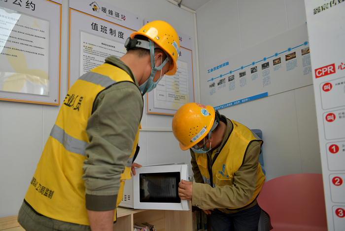 建筑工人用微波炉热饭。