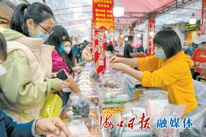 　　1月15日，市民在琼山区忠介路步行街的年货集市挑选心仪的年货商品。海口日报融媒体记者 苏弼坤 摄