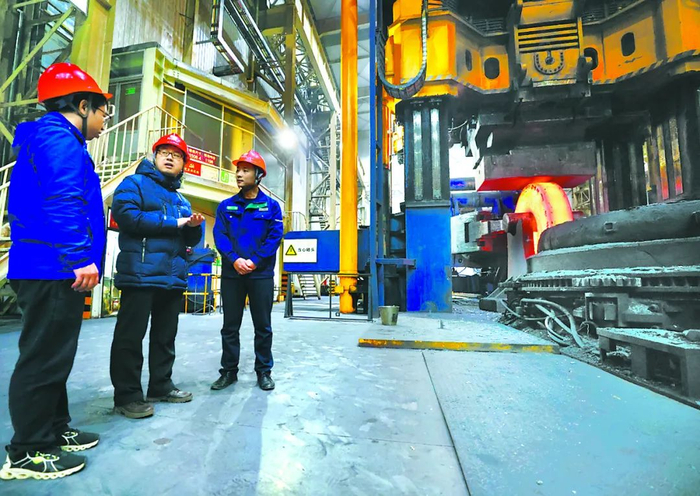 科研人员与加工人员现场交流大型套圈锻件扩孔工艺细节。（中科院金属所 供图）