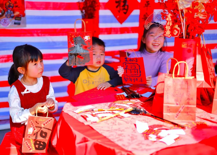 孩子们在年货街一摊位里自画购物袋，年味满满。清远日报签约摄影师 杨晓蓉 摄