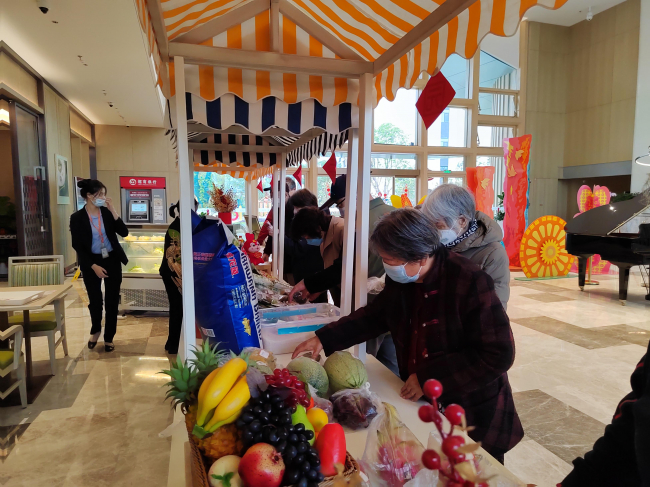 　　泰康之家·桂园的新春市集上长辈们正在采购年货