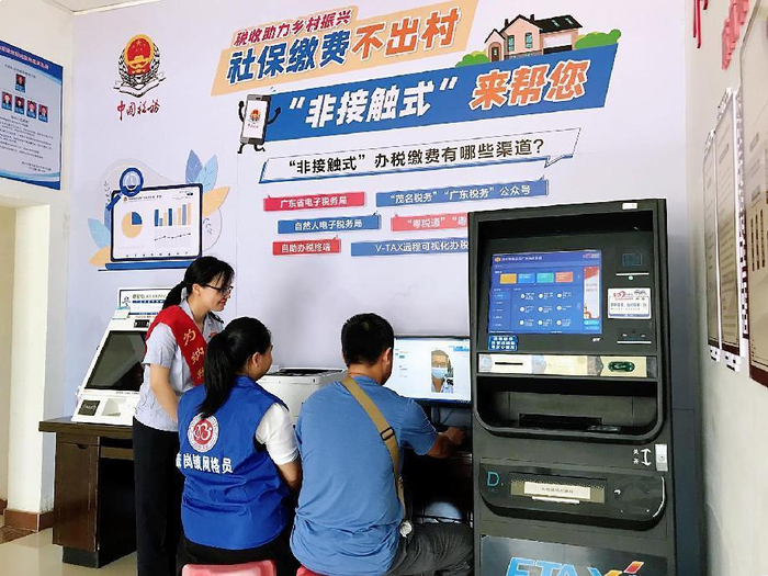 图为税务人员推广“社保缴费不出村“服务。