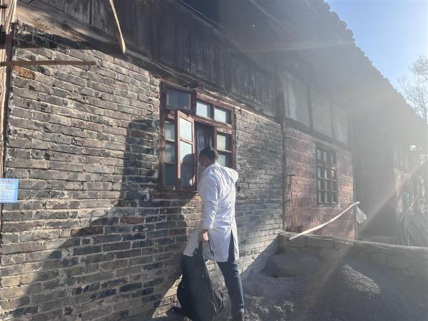 1月13日，贵州一村镇，村医通过窗户确认独居老人是否在家。 夏杰艺 摄