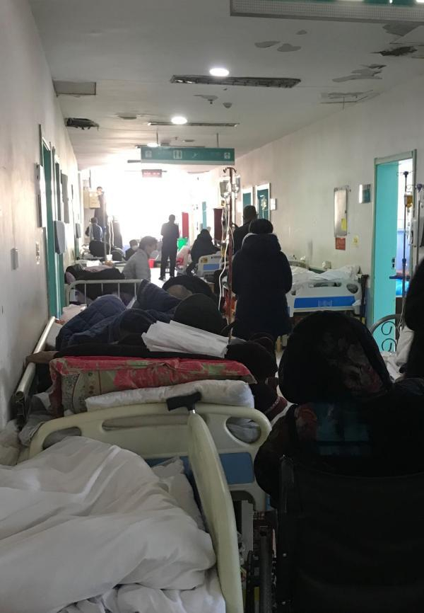 河南某县医院的临时住院部，走廊住满了加床的患者。 牛益彤 摄