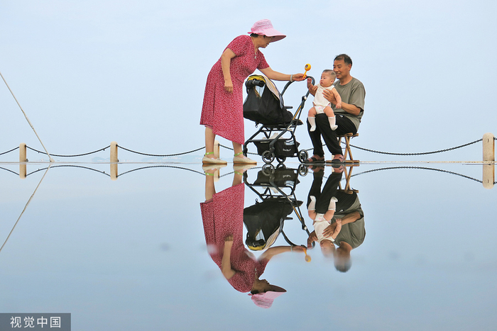 2022年7月29日，山东烟台，一对老年夫妇正在逗弄孙辈。（视觉中国）