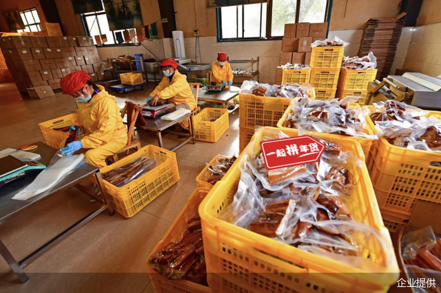 △拼多多年货节期间，“皇厨婶”店铺湖南腊制品销量上涨40%，工人们加紧打包发货。摄影/王伟