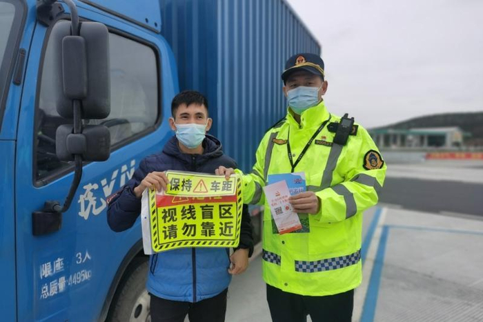 在货运主题的圣堂服务区，开阳高速志愿者为货车司机送上安全警示车贴。