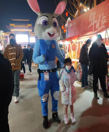 　　小朋友和年货节上身着兔子玩偶服的必胜客员工合影