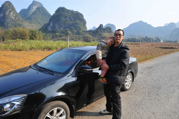 开车回家的韦寿宜和小儿子在314省道路边休息（2014年1月19日摄）。