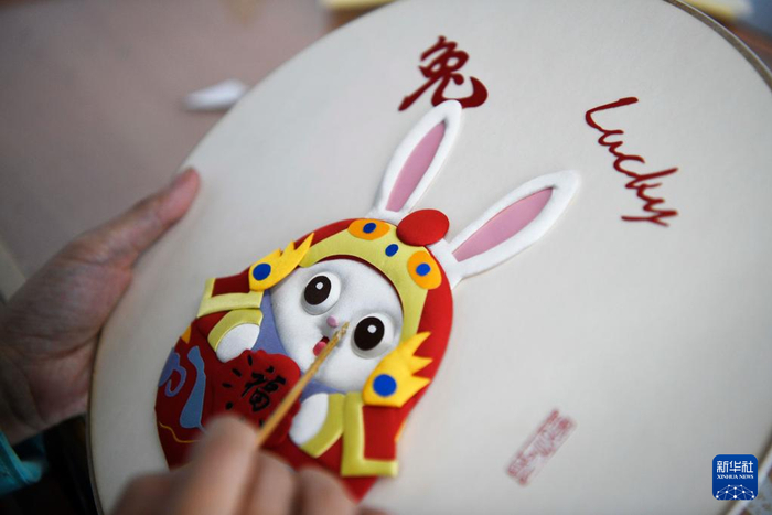 ▲河北省丰宁满族自治县布糊画手工艺人在制作憨态可掬、萌味十足的兔年主题布糊画，喜迎新春佳节。  新华社发 王立群 摄