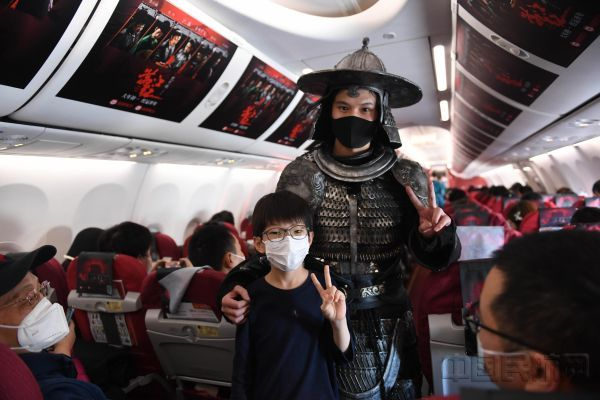 电影角色扮演者在客舱内与小旅客合影