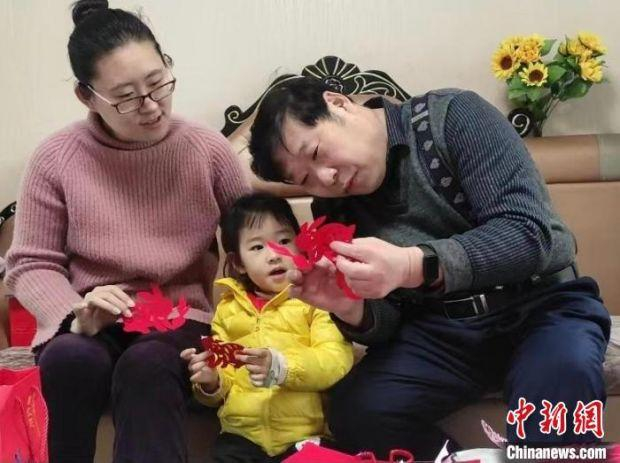 休息之余，陈耀也不闲着，他手把手教起三四岁的外孙女学习兔子剪纸。　受访者供图