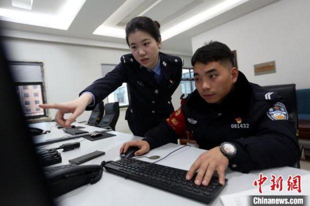 孙丰会同办案民警查看相关资料。　 梁西征 摄