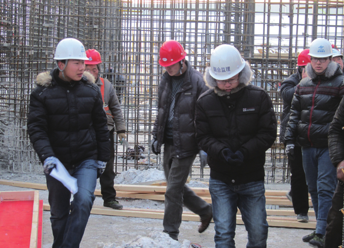 薛子华（左一）组织监理验收钢筋质量
