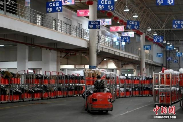 近日，昆明国际花卉拍卖交易中心有限公司交易运输仓库内，工作人员忙着运送挑选好的鲜花。中新社记者 李嘉娴 摄