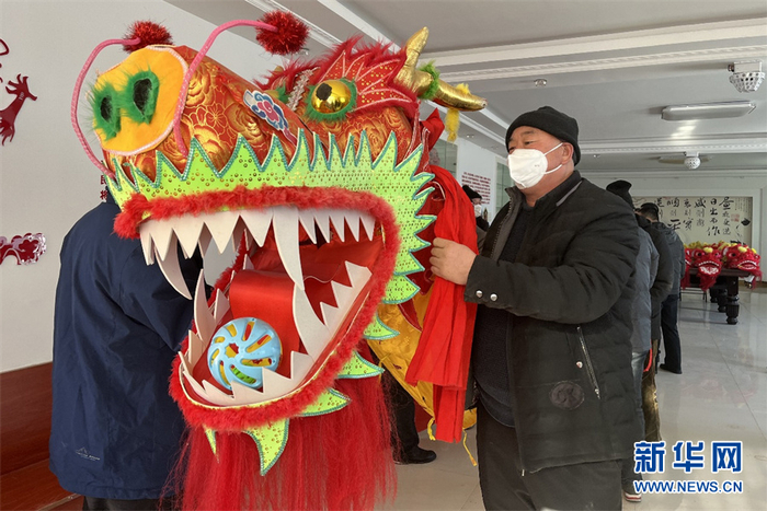 甘河子镇居民正在做舞龙前的准备工作。新华网发 张婧摄