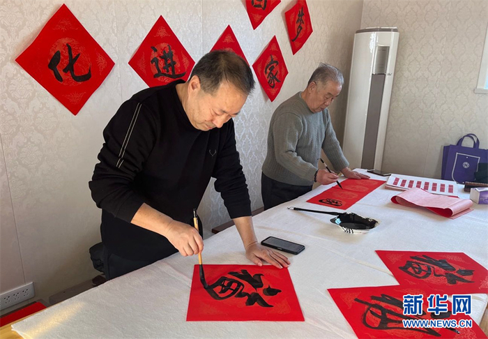 乌苏市书法协会老师现场写春联。新华网发 张婧摄