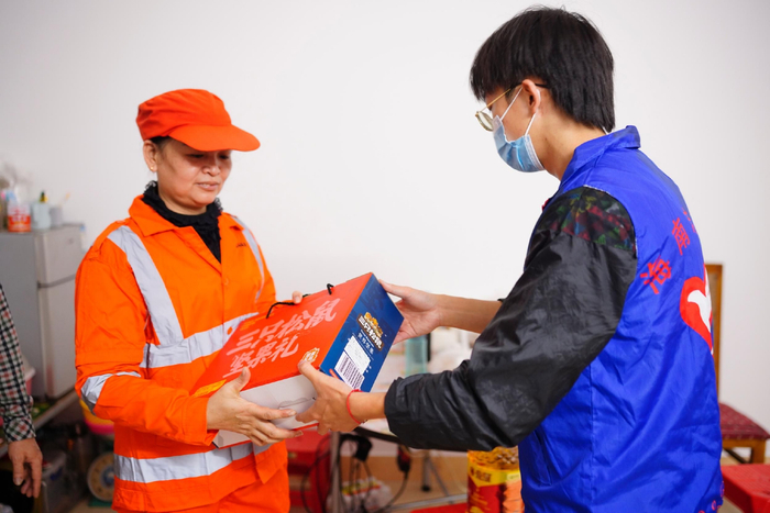 春节前夕，环卫工陈海英收到海口市青椰志愿服务中心主给户外工作者送来的年货。实习生 林晓璇 摄