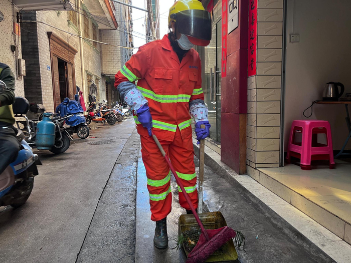 　　陈海英清扫街道上的垃圾。实习生 林晓璇 摄