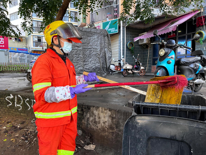 　　陈海英清扫街道上的垃圾。实习生 林晓璇 摄