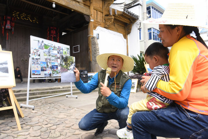 2022年05月17日，在建德市航头镇航川村，“堂前燕”宣讲员范胜利点评村民陆庆娟的手机摄影作品。新华社记者 翁忻旸 摄