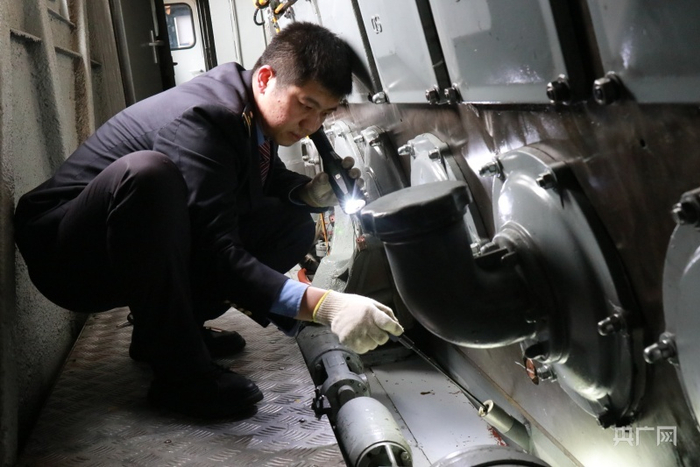 臧珂正在对热备机车机械间内部件进行检查（央广网发 张聪奕 摄）