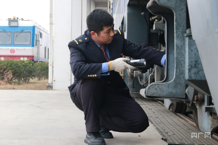 臧珂正在对热备机车走行部进行检查（央广网发 郑文博 摄）