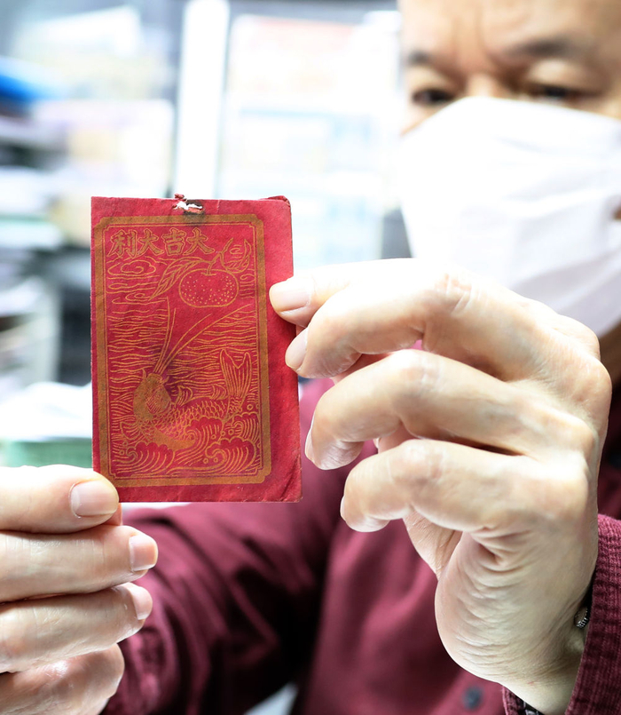 香港历史博物馆名誉顾问郑宝鸿展示自己收藏的利是封（1月13日摄）。新华社记者 李钢 摄