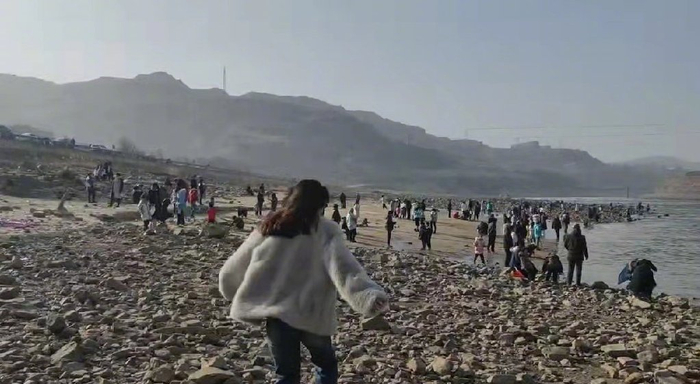 1月7日下午，网友“小仙女”到三门峡大坝附近网红景点拍照，河边约上百人在游玩。受访者供图