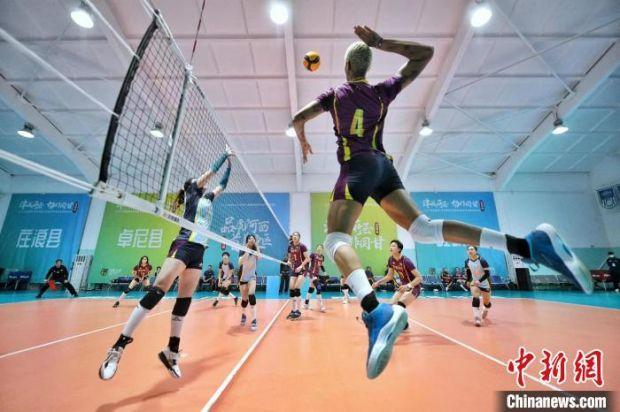 天津女排众将在新赛季出征仪式后分成两组进行对抗赛，4号外援瓦尔加斯（右）在网前跃起扣球。　佟郁　摄