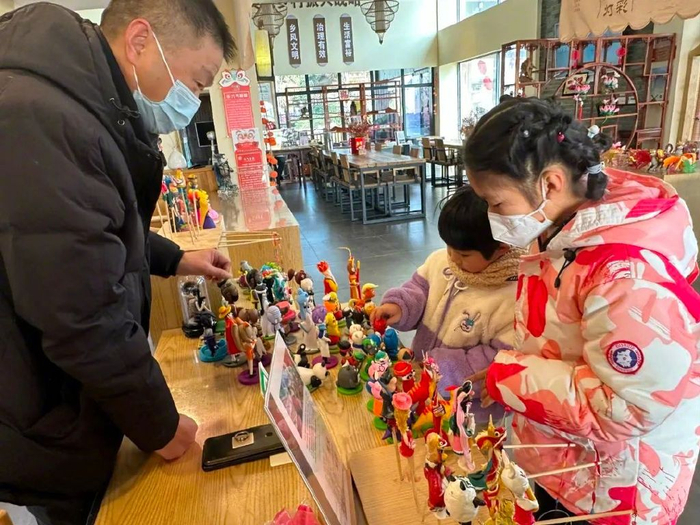 游客在江宁美丽乡村景区金陵水乡·钱家渡赏非遗产品。通讯员 李婷 供图