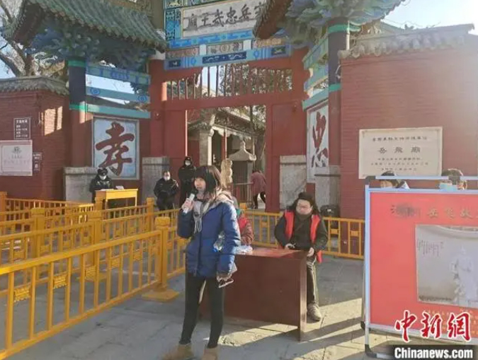 　　图为一名游客在岳飞纪念馆门前背诵《满江红》。　靳晓晶 摄