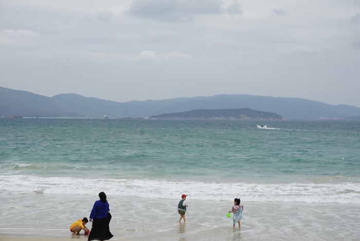 天气不暖和，海边下水的人不多，仅有几个孩童在踩水，受访者供图