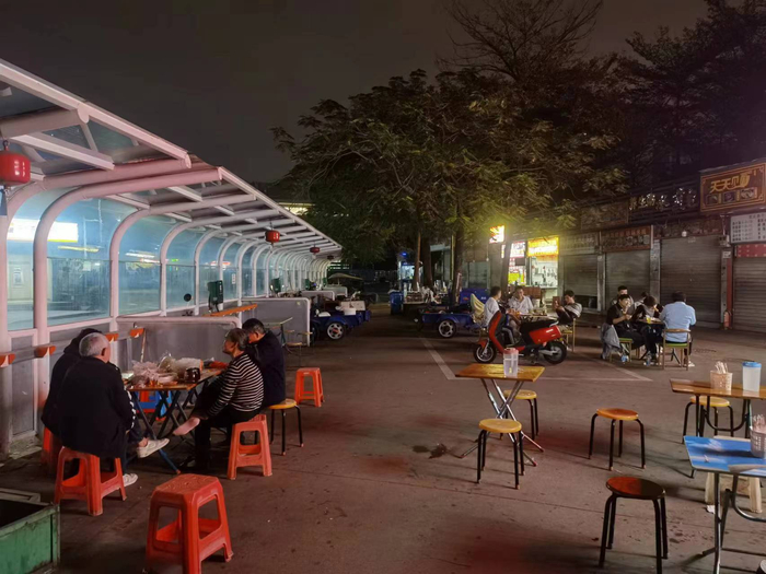 坐在小吃店门口桌椅上的众人 陈熊海摄