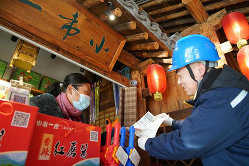 国网辽宁本溪供电公司员工向景区商户讲解安全用电常识。