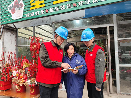 国网江西南昌县供电公司员工为商户讲解安全用电知识。