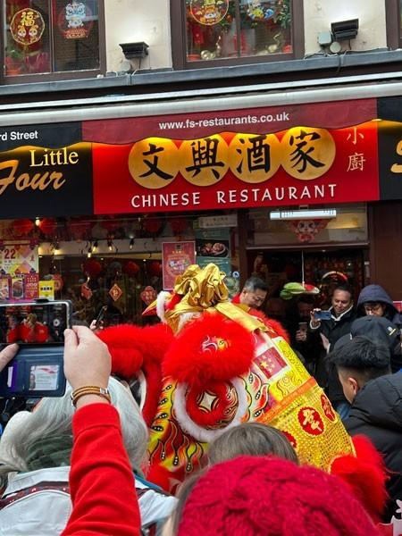中国城粤菜馆门口围观舞狮的人群。刘奕/摄