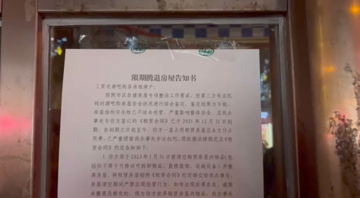 酒吧街商户大门上张贴的《限期腾退房屋告知书》。摄影/魏媛