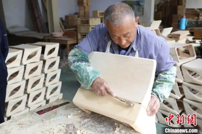 图为廊坊香河天音乐器有限公司工作人员制作手风琴风箱。