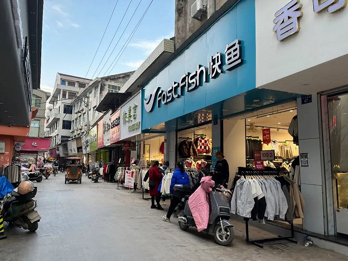 ▲ 小镇商业街一角，低矮的套房和遍布的服装店。钟艺璇 / 摄