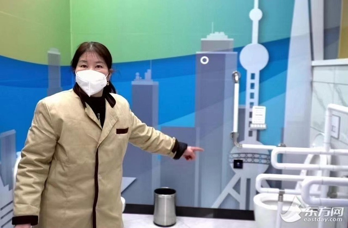 图说：保洁员介绍第三卫生间使用情况。