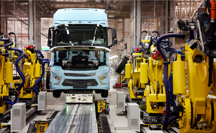 在陕汽重卡扩能项目现场，一辆重卡在汽车总装生产线轮胎自动化装配拧紧无人工作站进行装配。刘潇摄（新华社）