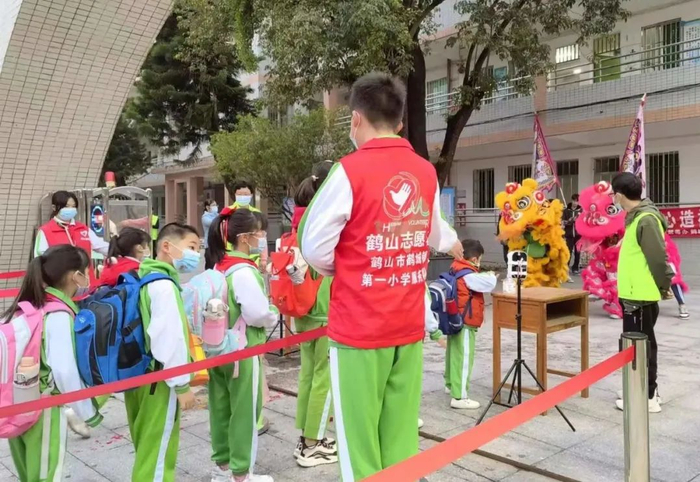 在鹤山市鹤城一小，学生陆续排队进校。